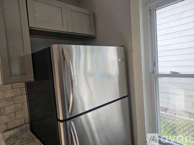 A stainless steel refrigerator is in a kitchen.