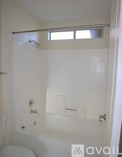 A white bathroom with a tub and toilet.