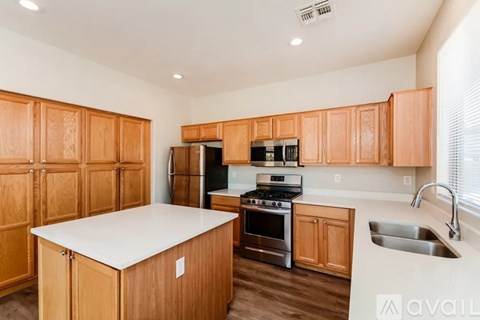 A kitchen with wooden cabinets and a white island.