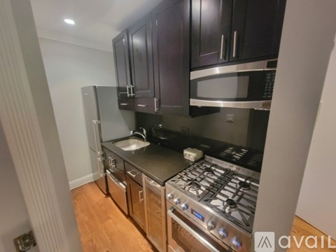 A kitchen with dark wood cabinets and stainless steel appliances.