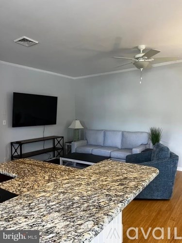 A living room with a television, sofa, and a coffee table.