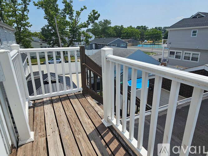 A deck with a pool in the background.
