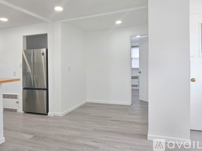 A spacious kitchen with a stainless steel refrigerator and wooden countertops.