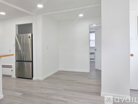 A spacious kitchen with a stainless steel refrigerator and wooden countertops.