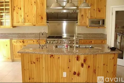 A kitchen with wooden cabinets and a granite countertop.