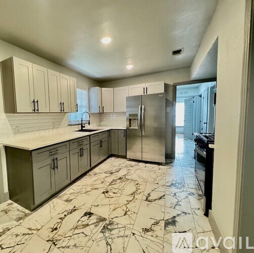 A kitchen with marble flooring and stainless steel appliances.