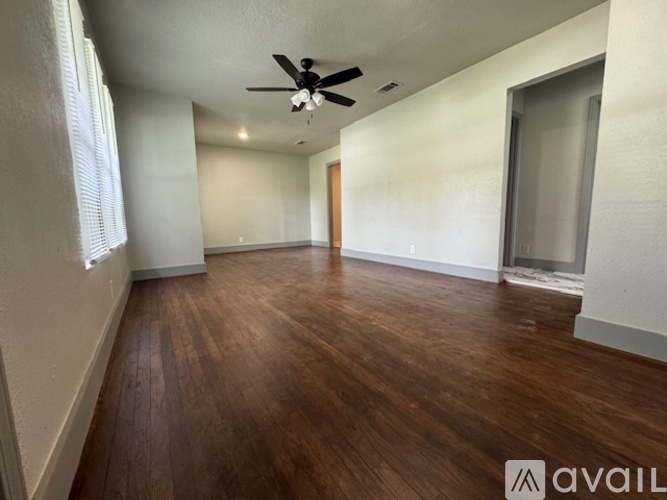 A room with wooden flooring and a ceiling fan.