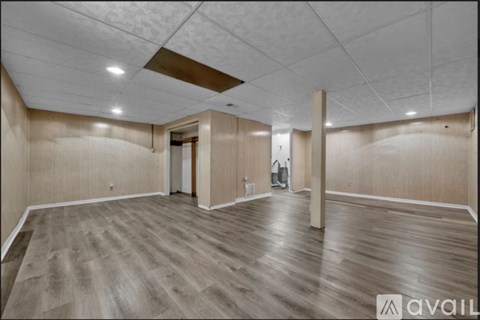 A spacious room with wooden flooring and a white ceiling.