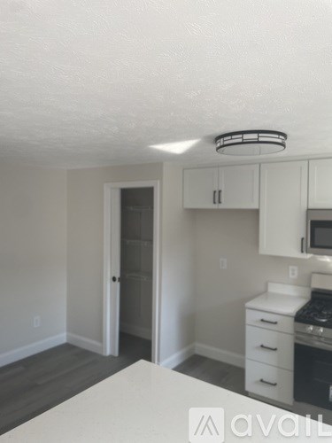 A kitchen with white cabinets and a white island.