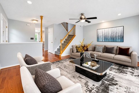 A living room with a staircase and a couch.