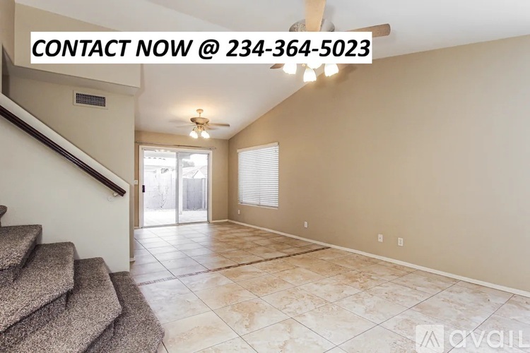 A room with a staircase and a door leading to a balcony.