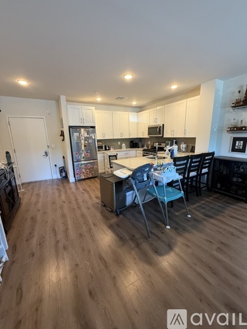 A kitchen with wooden floors and a dining table with chairs.