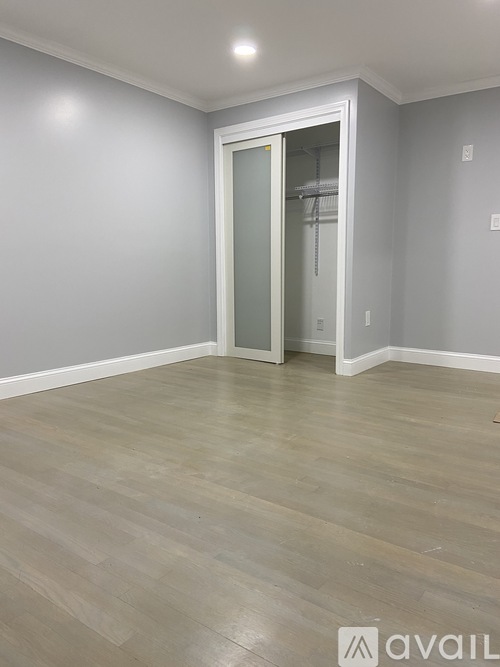 A room with a wooden floor and a white door.