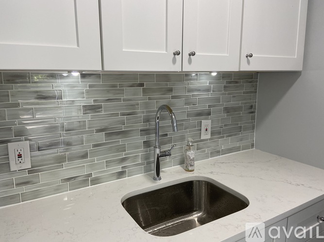 A kitchen with a sink and a backsplash.