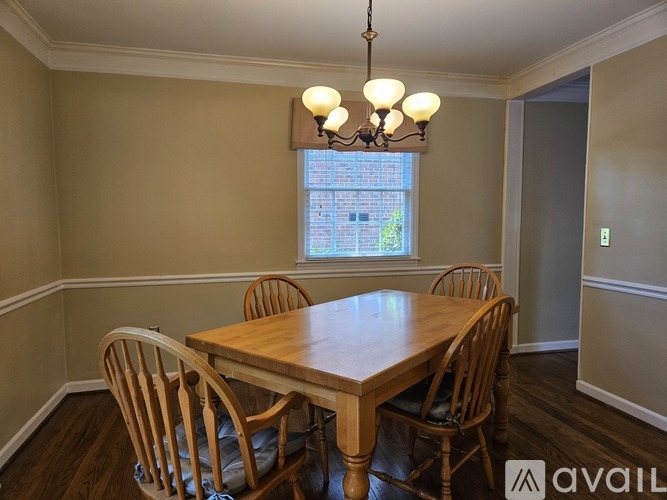 A dining room with a wooden table and chairs.