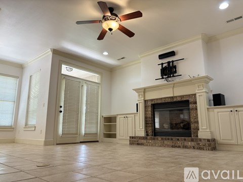 A living room with a fireplace and a ceiling fan.