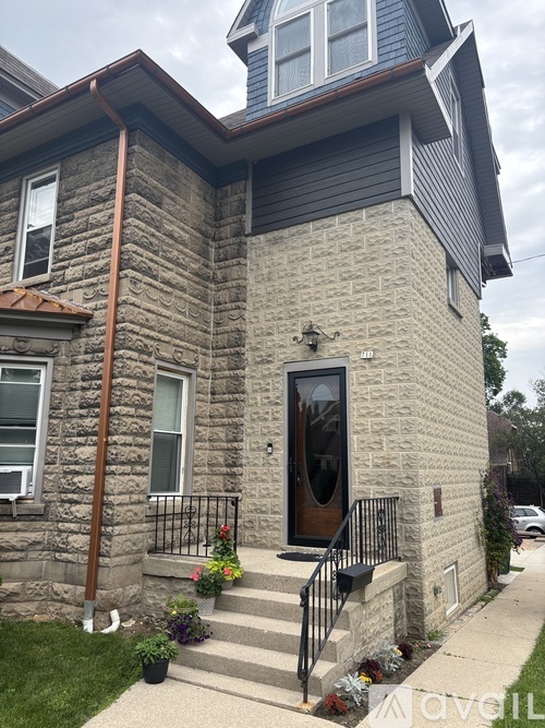 A house with a grey stone exterior and a brown door.