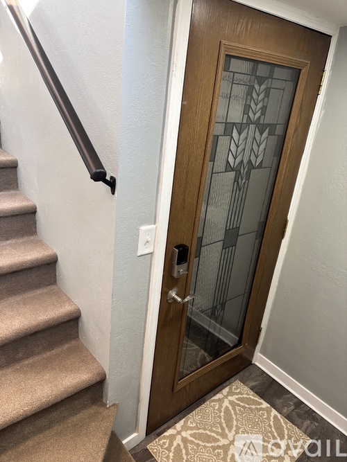 A wooden door with a glass panel and a handle.