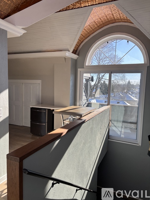 A room with a large window and a view of a snowy street outside.