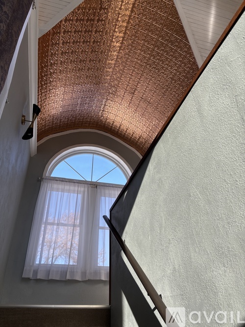 A copper ceiling with a window and curtains.