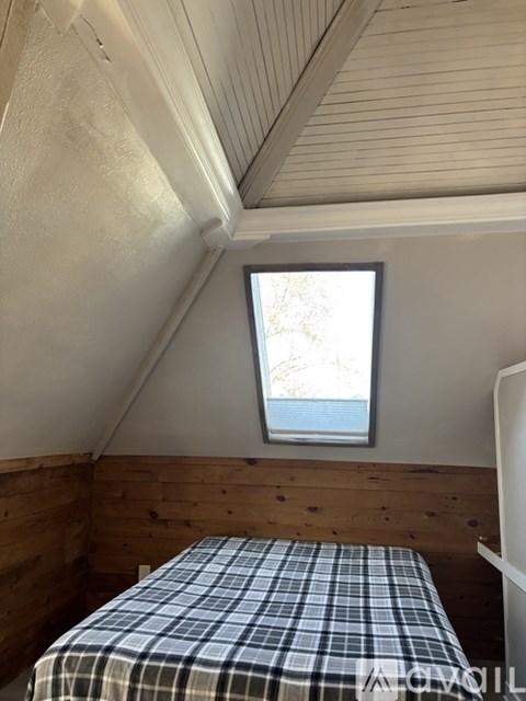 A bedroom with a bed and a window.