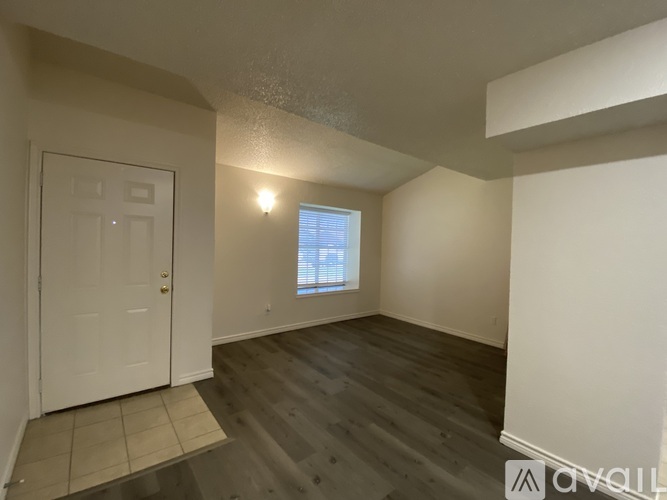 A room with a white door and a window with blinds.