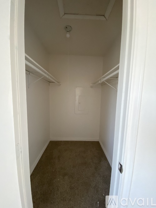 A small, empty room with a carpeted floor and white walls.