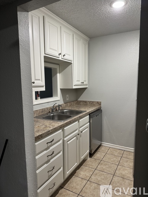 A kitchen with white cabinets and a granite countertop.