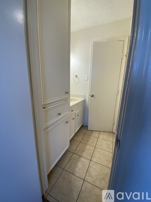 A hallway with a white door and a white cabinet.