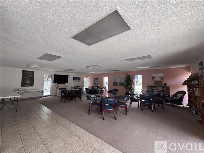 A spacious room with a white ceiling and a collection of chairs.