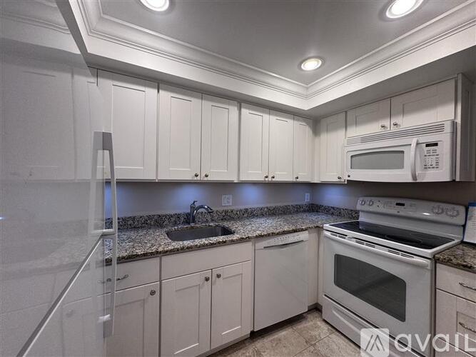 A kitchen with white cabinets and appliances.