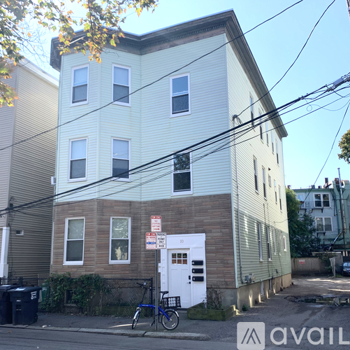 A two-story building with a white door and a bicycle parked in front.