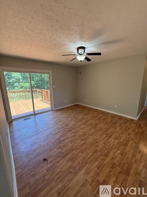 A room with wooden flooring and a ceiling fan.