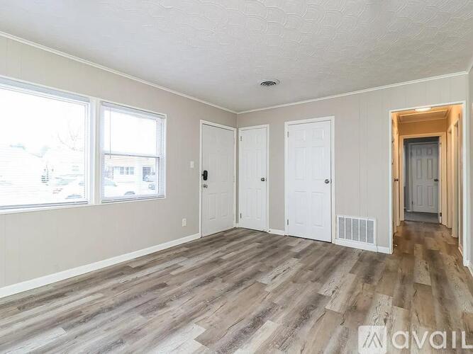 A spacious living room with hardwood floors and a staircase leading to the upper level.