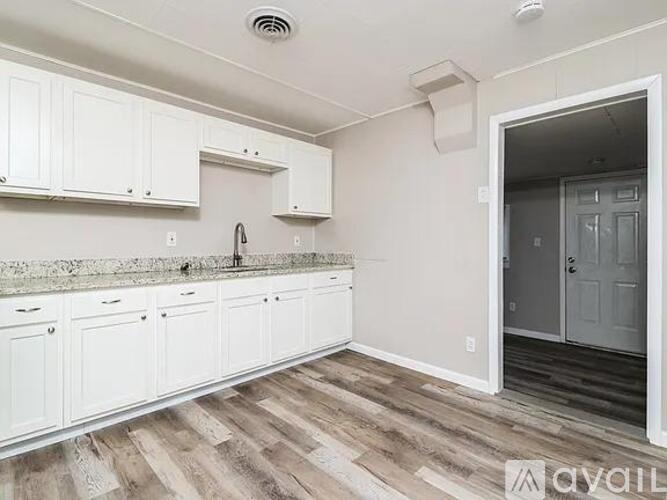 A spacious room with beige walls and carpeted floor.