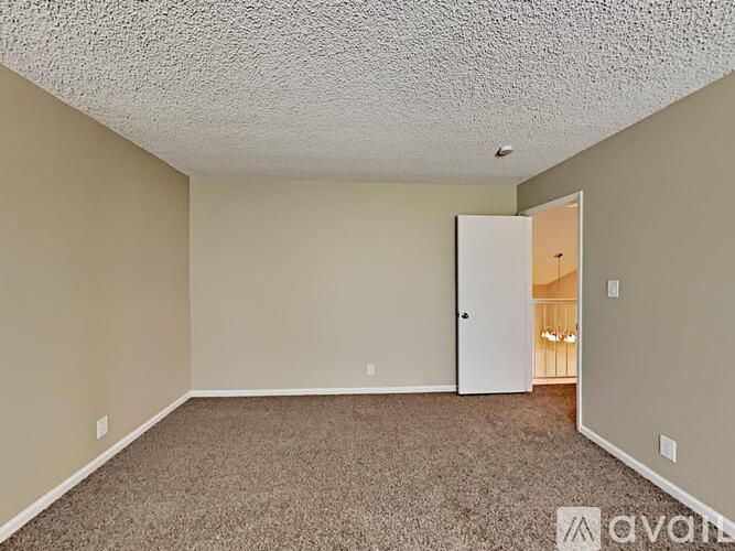 A room with wood flooring and a doorway leading to another room.