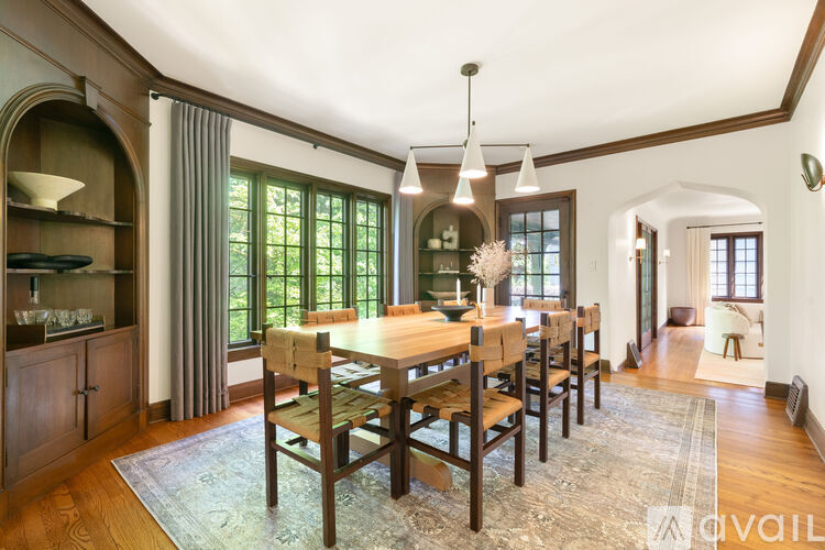 A dining room with a table and chairs.