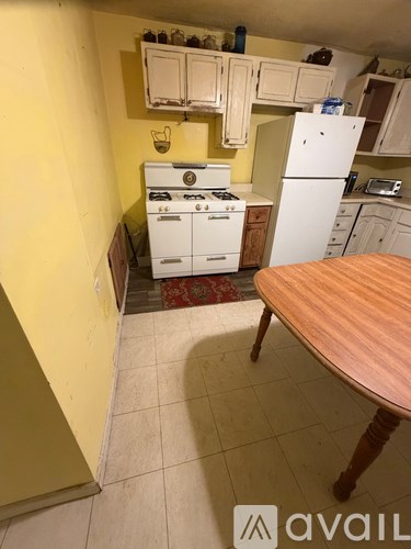 A kitchen with yellow walls and white appliances.