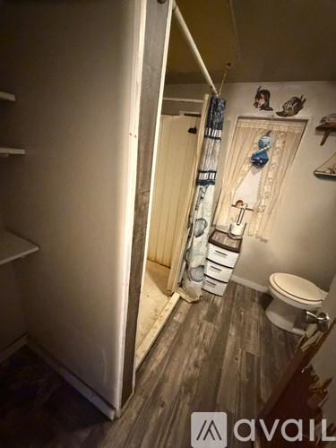 A bathroom with a toilet, a sink, and a shower curtain.