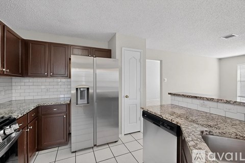 A kitchen with brown cabinets and a white door.