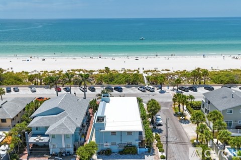 A beachfront community with a clear blue sky and ocean in the background.