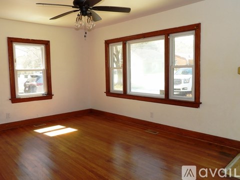 A room with wooden floors and a ceiling fan.