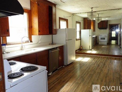 A kitchen with wooden cabinets and a white stove top oven.