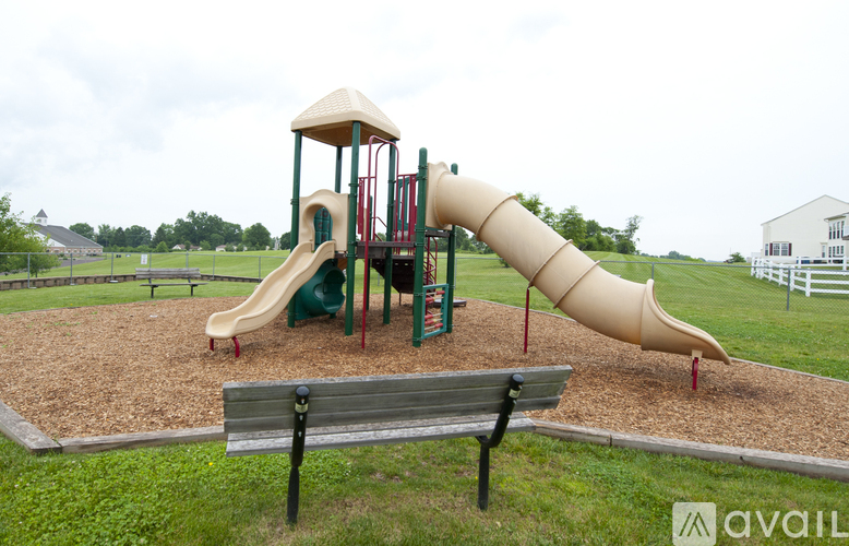 A playground with a slide and a bench.