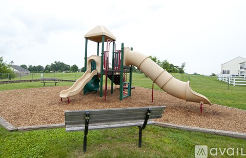 A playground with a slide and a bench.