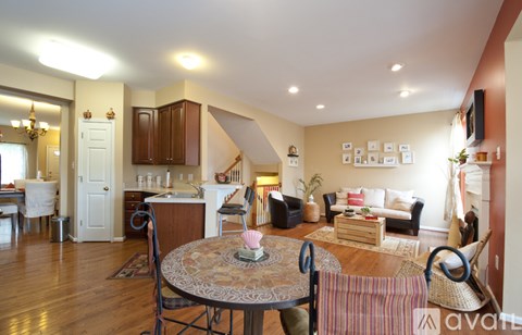 A living room with a dining table and chairs.