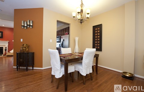 A dining room with a wooden table and chairs.