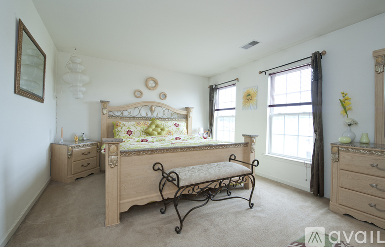 A bedroom with a large bed and a bench in front of it.