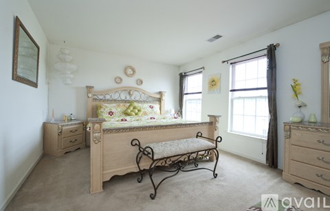 A bedroom with a large bed and a bench in front of it.