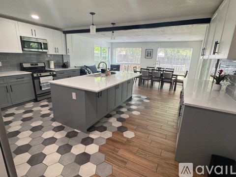A kitchen with a checkered floor and a dining table.